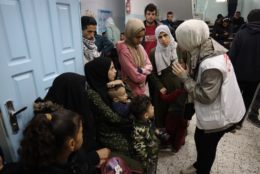 Medical activity manager talks to patients in Rafah