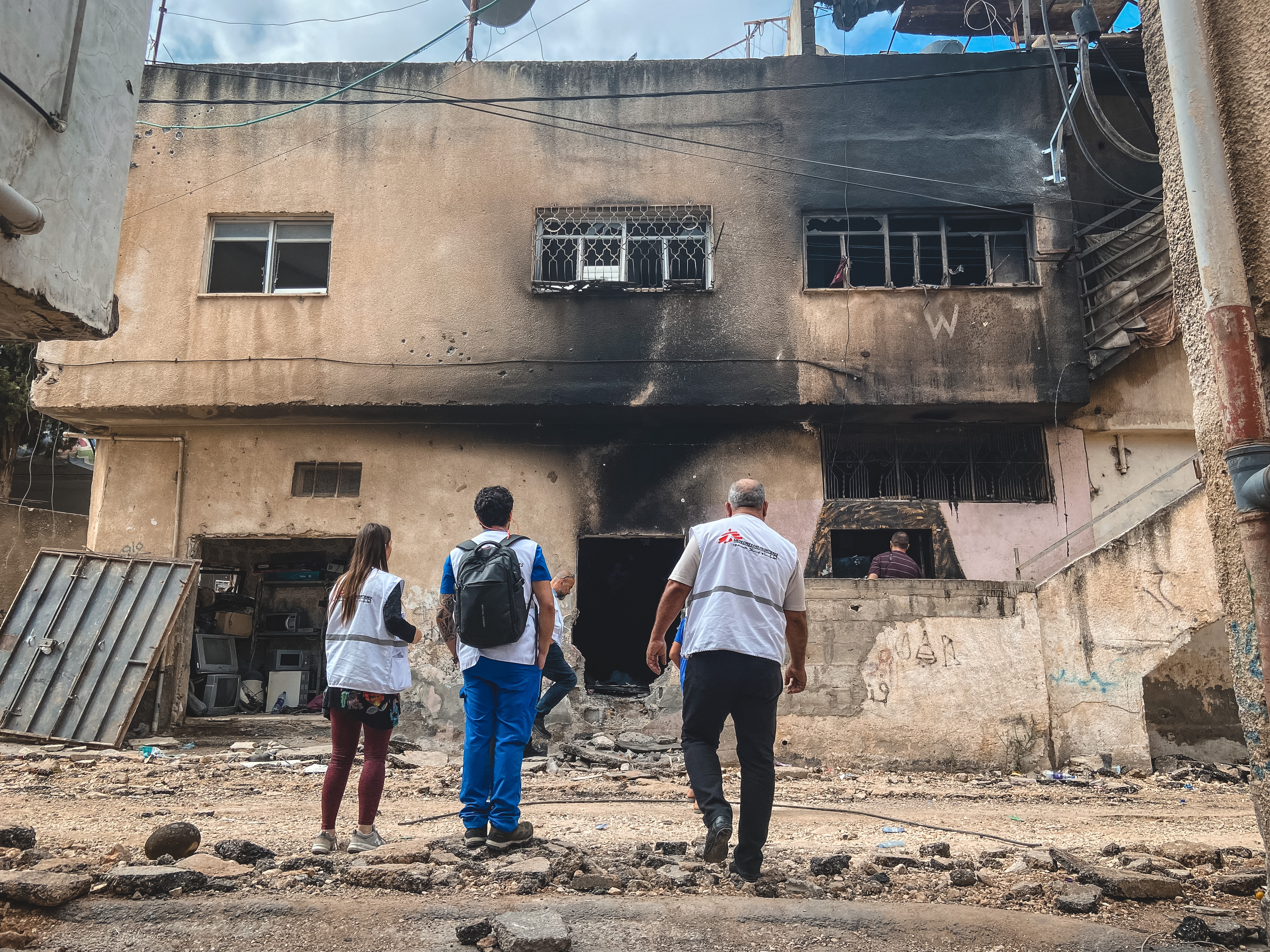 MSF team standing in front of bomb building in Jenin.