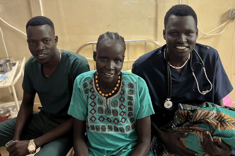 Nyakuola Nguot Gang sits with MSF midwife on duty, Duol, and midwife assistant Dor, not quite two hours after giving birth to her sixth child, daughter Nyamuch on 1 January 2025 in Old Fangak. © MSF